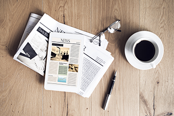 Stock photo of newspapers and a cup of coffee